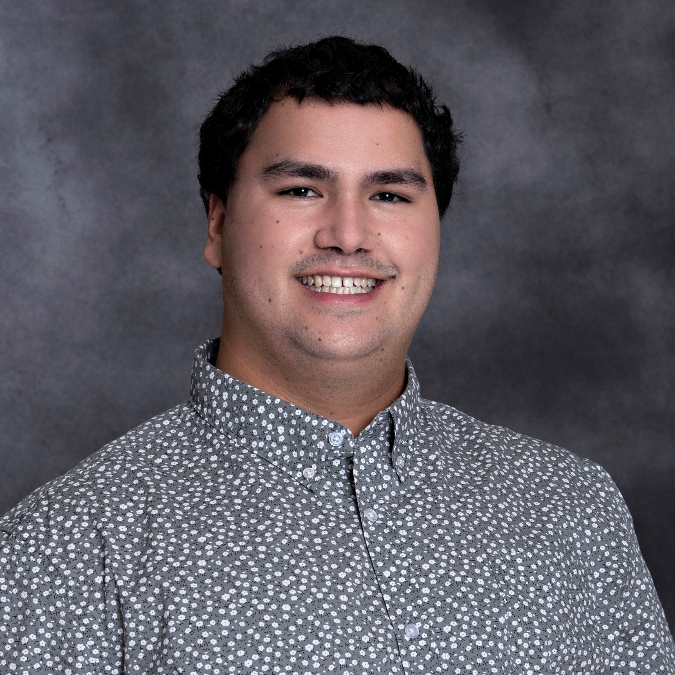 Headshot of a person in a collared shirt